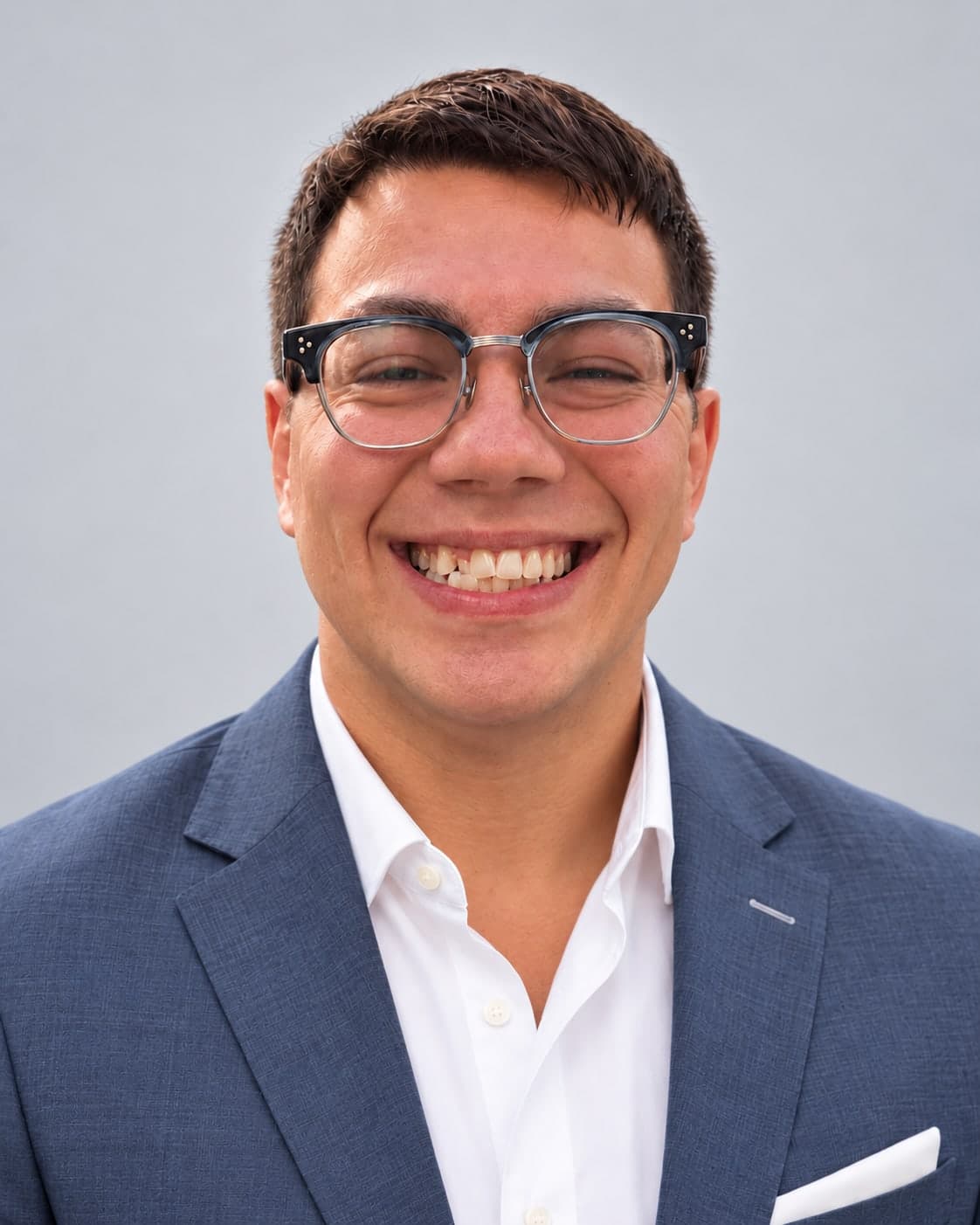 Stephen Kolokithas, smiling, in a navy blazer and white shirt