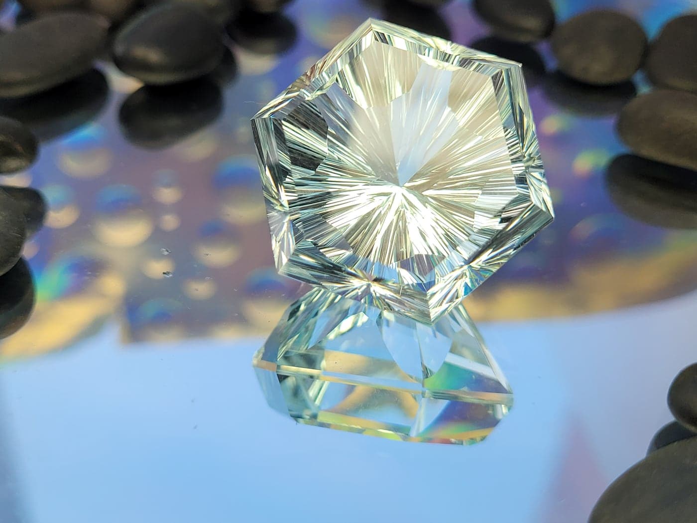 A pale green hexagonal gemstone with a starburst of fine facets radiating from its center
