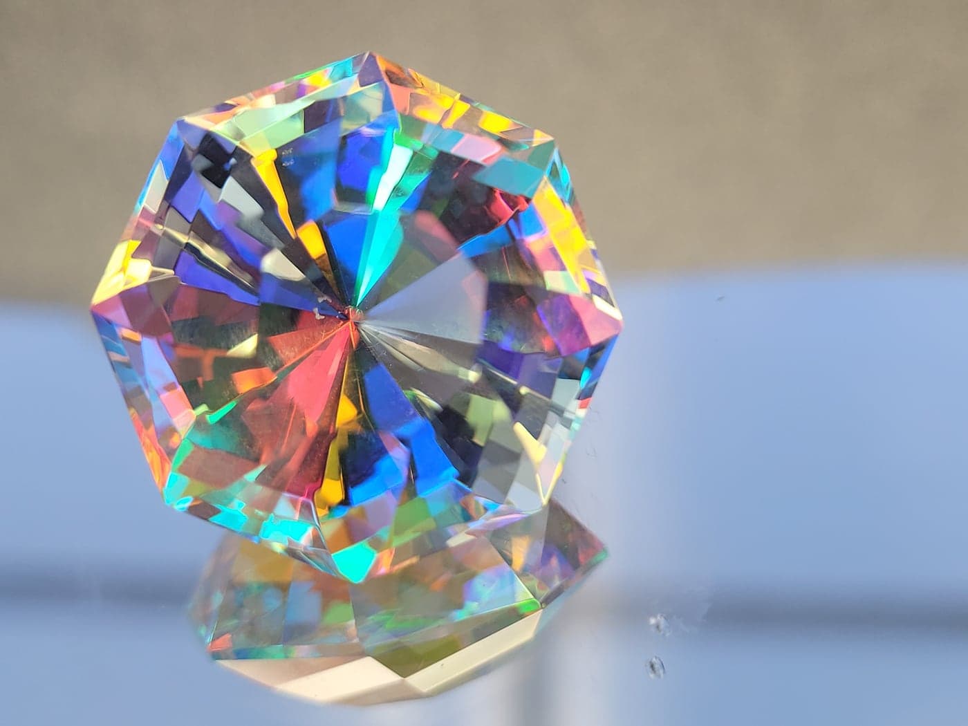 A clear octagonal gemstone scattering every color of the rainbow