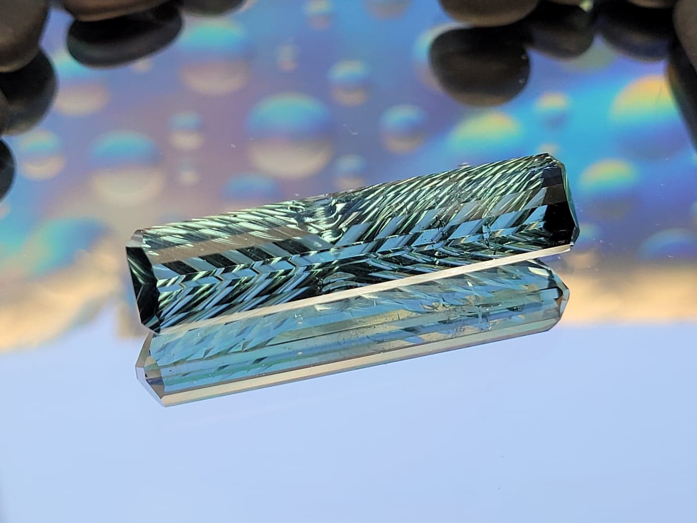 A long seafoam-green gemstone carved in a chevron pattern